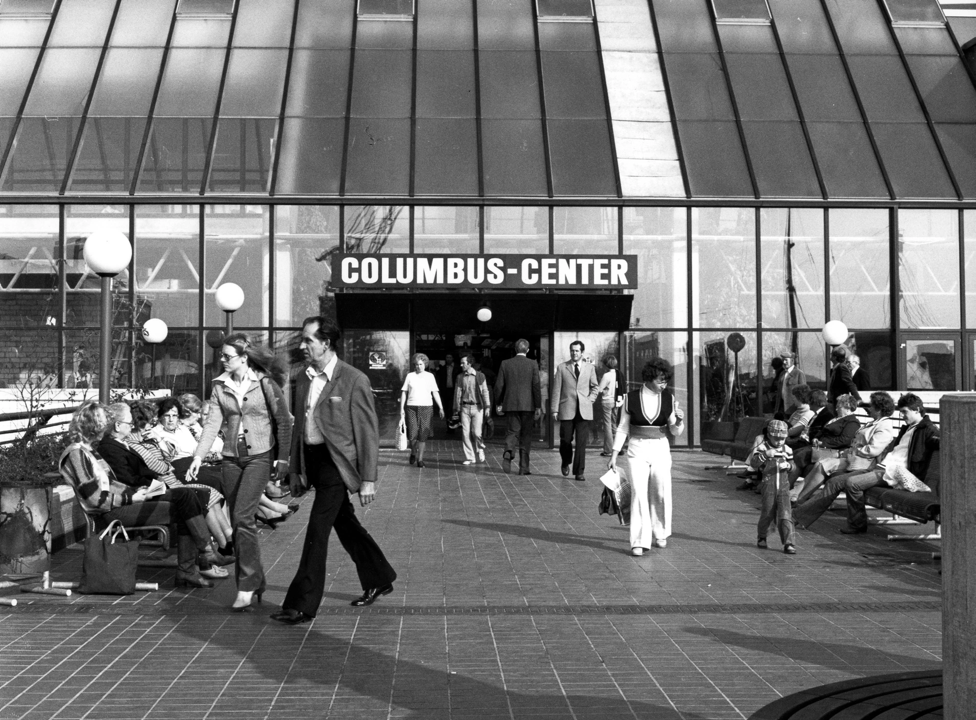 Menschen in Schlaghosen vor dem Eingang des Columbus-Centers