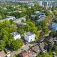 Luftansicht einer Stadt. Drei identische aber voneinander entfernte Wohnblöcke sind erkennbar