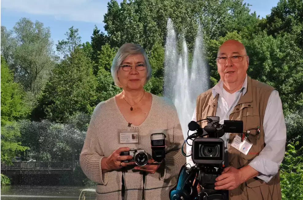 Mann und Frau stehen mit Kameraausrüstung vor Bäumen in der Vahr