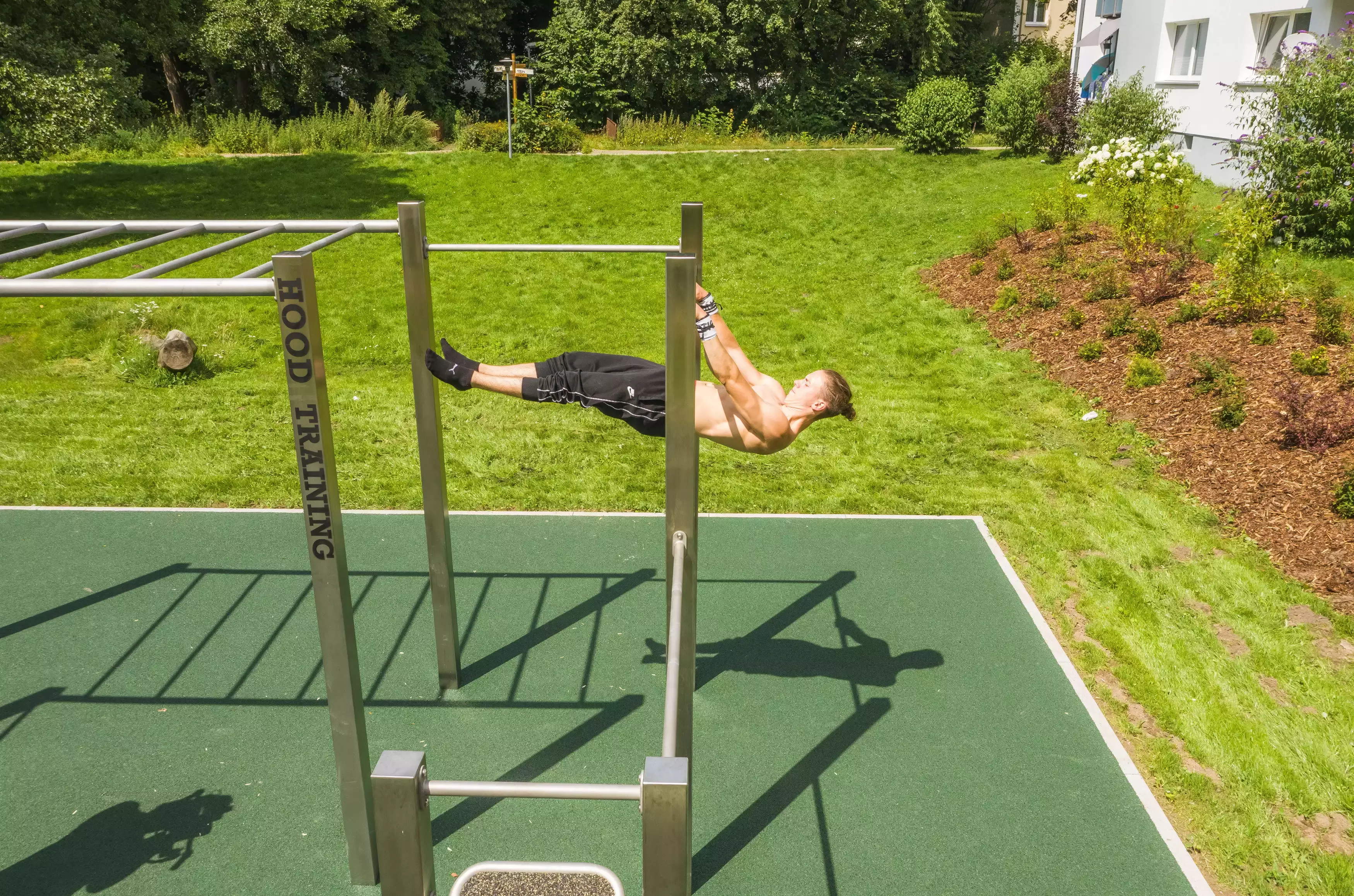 Eine muskulöse Person trainiert an einem Freiluft-Gym