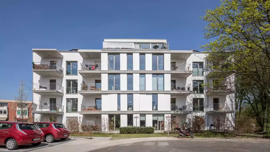 Ein moderner weisser Wohnblock mit Balkonen im Sonnenlicht