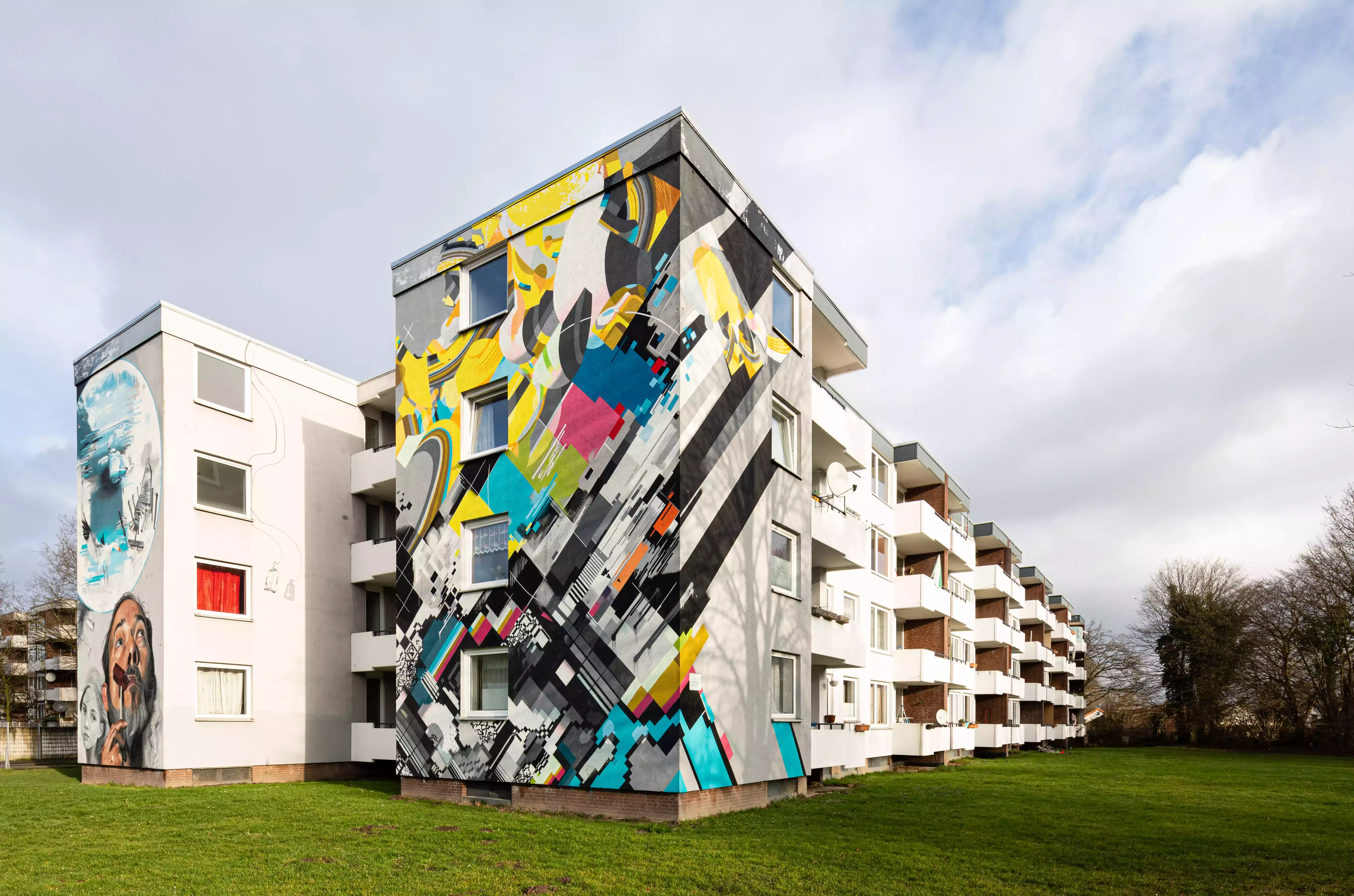 Ein modernes abstraktes Wandbild auf einem weissen Wohnblock
